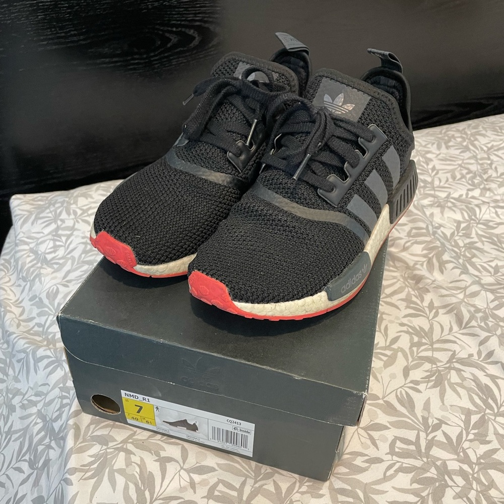 NMD black sneakers with red bottoms